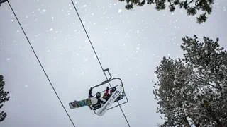 People on chair lift while snowing